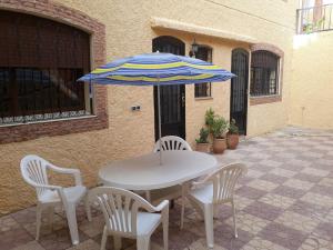 a white table with chairs and an umbrella at The Orchard Cozy & Comfy Apartment 1 in Ifrane