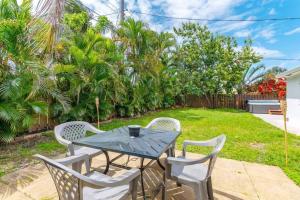 a table and chairs on a patio with a yard at Ventur Tropical w Hot Tub Close to Beach in Deerfield Beach +18 photos