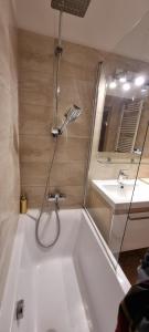 a bath tub with a shower and a sink at HUGE APARTMENT next to train station close to the city center in Staré Mesto +20 photos