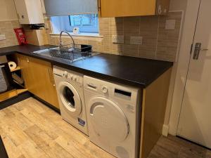 a kitchen with a washer and dryer under a counter at Peaceful Place in Falkirk
