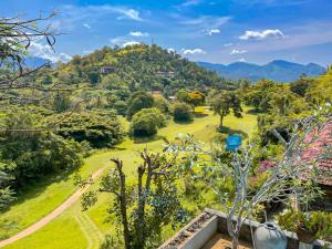 a view of a park with mountains in the background at Tibline by Gotravelfix in Kudadeniya