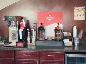 a counter with bottles of coffee on it at Boarders Inn and Suites by Cobblestone Lamar Missouri in Lamar