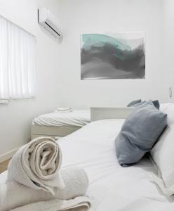a white bed with a towel on top of it at Costa by Hawkins Algeciras - Interior 1B in Algeciras