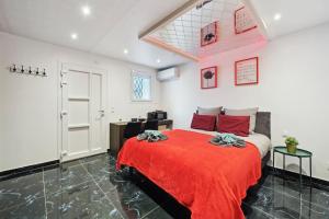 a bedroom with a bed with a red blanket at Love Room - Suite avec jacuzzi et sauna privatif in Corbeil-Essonnes