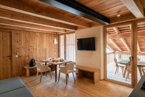 a dining room with a table and chairs and a television at OBERBUCHFELDER historic farmhouse in Laion