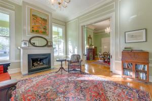a living room with a fireplace and a rug at Ornate Victorian Home with Courtyard and Fire Pit! in Columbus