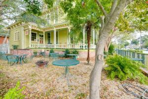 a yellow house with a table and chairs in the yard at Ornate Victorian Home with Courtyard and Fire Pit! in Columbus
