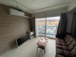 a living room with a couch and a large window at ホテル小樽キャナルビュー 海宝樓アネックス in Otaru +15 photos