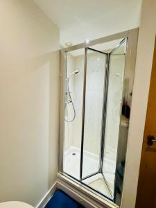 a shower with a glass door in a bathroom at The Metro Oasis in Edinburgh