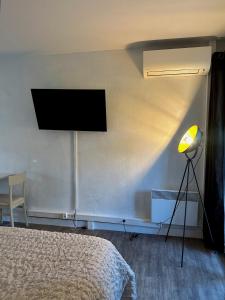 um quarto com uma cama e uma televisão na parede em Nid douillet avec terrasse au calme em Arles mais 11 fotografias