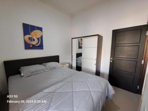 a bedroom with a bed and a black door at Dinanti Homestay1 in Gondowulung +14 photos