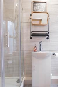 a bathroom with a shower and a white sink at Luxury Studio - Free Parking - Great Location in Leeds +27 photos