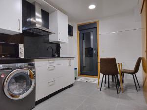 a kitchen with a washing machine and a washer at Casa Rios in Redondela