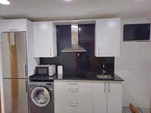 una cocina con nevera y lavadora en Casa Rios, en Redondela