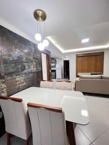 une salle à manger avec une table et des chaises blanches dans l'établissement Apartamento com 3 quartos no centro de Domingos Martins, à Domingos Martins 13 autres photos