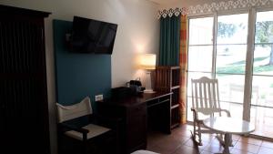 a room with a desk and a tv on a wall at Village Sainte Luce, Martinique - maeva Home - Studio 3 Personnes - Prestige MAE-7394 in Sainte-Luce