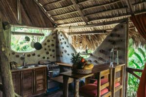 cocina con mesa y fogones en una habitación en Bungalows India, El Valle, Samana, en Santa Bárbara de Samaná