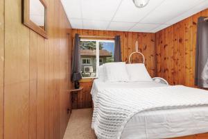 a bedroom with a bed and a window at Chippewa Bluffs Resort Spacious Combined 4BR 4BA Cabins in Barryton