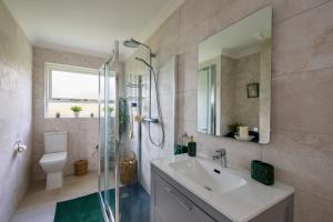 a bathroom with a sink and a shower with a mirror at Fox House Sleeps 8 w Parking 5 min to Kilmessan in Navan +41 photos