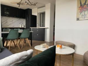 a living room with a couch and a table and a kitchen at Havre de paix en appartement in Valence