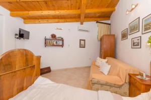a bedroom with a bed and a couch at Apartments Draga in Vrboska