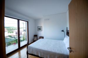 a bedroom with a bed and a large window at Casa de Trás-o-Muro in Vila Real +37 photos