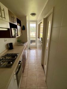a kitchen with a stove and a tile floor at Departamento San Pedro de la Paz in San Pedro de la Paz