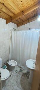 a bathroom with two sinks and a toilet and a shower at La Cima HOSTERIA in El Chalten
