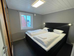 a large bed in a room with a window at Nostalgic Nook 27 by Stavanger BnB in Stavanger +4 photos