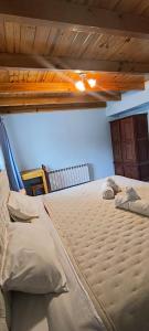 a large bed in a bedroom with a wooden ceiling at La Cima HOSTERIA in El Chalten +10 photos
