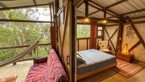 a room with a bed and a hammock in a tent at Refugio en las Nubes in Santa Elena