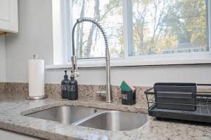 a kitchen sink with wine bottles and a window at Quiet & Quaint apartment, 5 mins to airport and 15 mins to downtown in Atlanta +25 photos