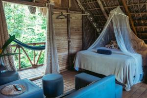 1 dormitorio en una casa del árbol con cama y ventana en Bungalows India, El Valle, Samana, en Santa Bárbara de Samaná 28 fotos más