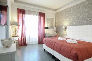 a bedroom with a large bed with red sheets and a window at RomAntic Dreams Guest House in Rome