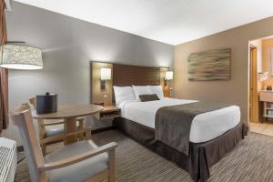 ein Hotelzimmer mit einem großen Bett und einem Tisch in der Unterkunft Best Western Plus Landing View Inn & Suites in Branson