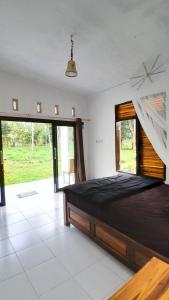 a bedroom with a bed and a large window at Sollo Sollo Homestay in Lemonga