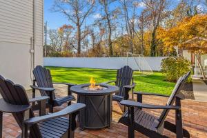 a patio with four chairs and a fire pit at Walk to the Beach - Modern Home with FirePit and Bikes in Yarmouth