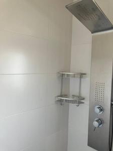 a shower in a bathroom with a white wall at Descanso del GUERRERO in San Miguel de Fluviá +38 photos