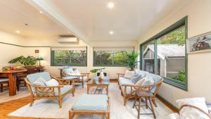 ein Wohnzimmer mit Stühlen und einem Tisch in der Unterkunft Kookaburra Cottage Pearl Beach in Pearl Beach