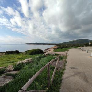una valla al lado de un camino al lado de un cuerpo de agua en Casa Gavina With Garden Alghero, en Fertilia 6 fotos más