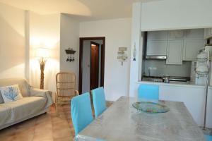 Una cocina y una sala de estar con mesa y sillas. en Casa Gavina With Garden Alghero, en Fertilia