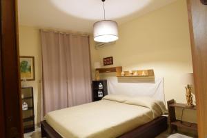 Un dormitorio con una cama blanca y una lámpara. en Casa Gavina With Garden Alghero, en Fertilia