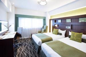 東京にあるホテルベルクラシック東京のベッド2台と椅子があるホテルの部屋