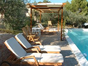 Un grupo de tumbonas junto a una piscina. en Apartment in a farmhouse with swimming pool, en Giano dellʼUmbria