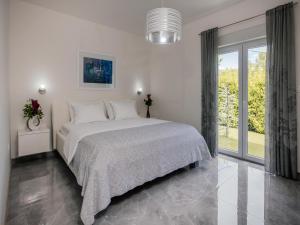 a white bedroom with a bed and a large window at Villa in Imotski near Blue & Red Lakes in Imotski +31 photos