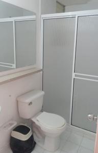 a white bathroom with a toilet and a shower at Sol del Valle Apartamento con Aire Acondicionado y piscina in Valledupar