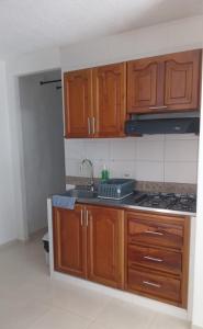 an empty kitchen with wooden cabinets and a sink at Sol del Valle Apartamento con Aire Acondicionado y piscina in Valledupar