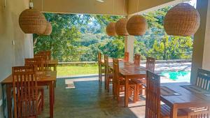 a restaurant with wooden tables and chairs and a large window at Tibline by Gotravelfix in Kudadeniya