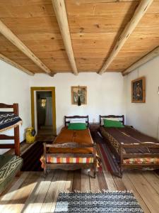 ein Zimmer mit zwei Betten und einer Holzdecke in der Unterkunft Estancia Santa Thelma in Gobernador Gregores