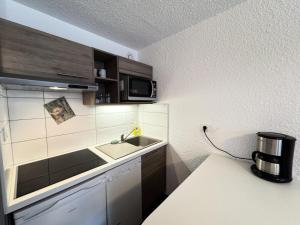 a small kitchen with a sink and a microwave at Résidence Bois Des Coqs - Studio confortable · Proche des pistes · Coin montagne & parking extérieur MAE-0294 in Champcella